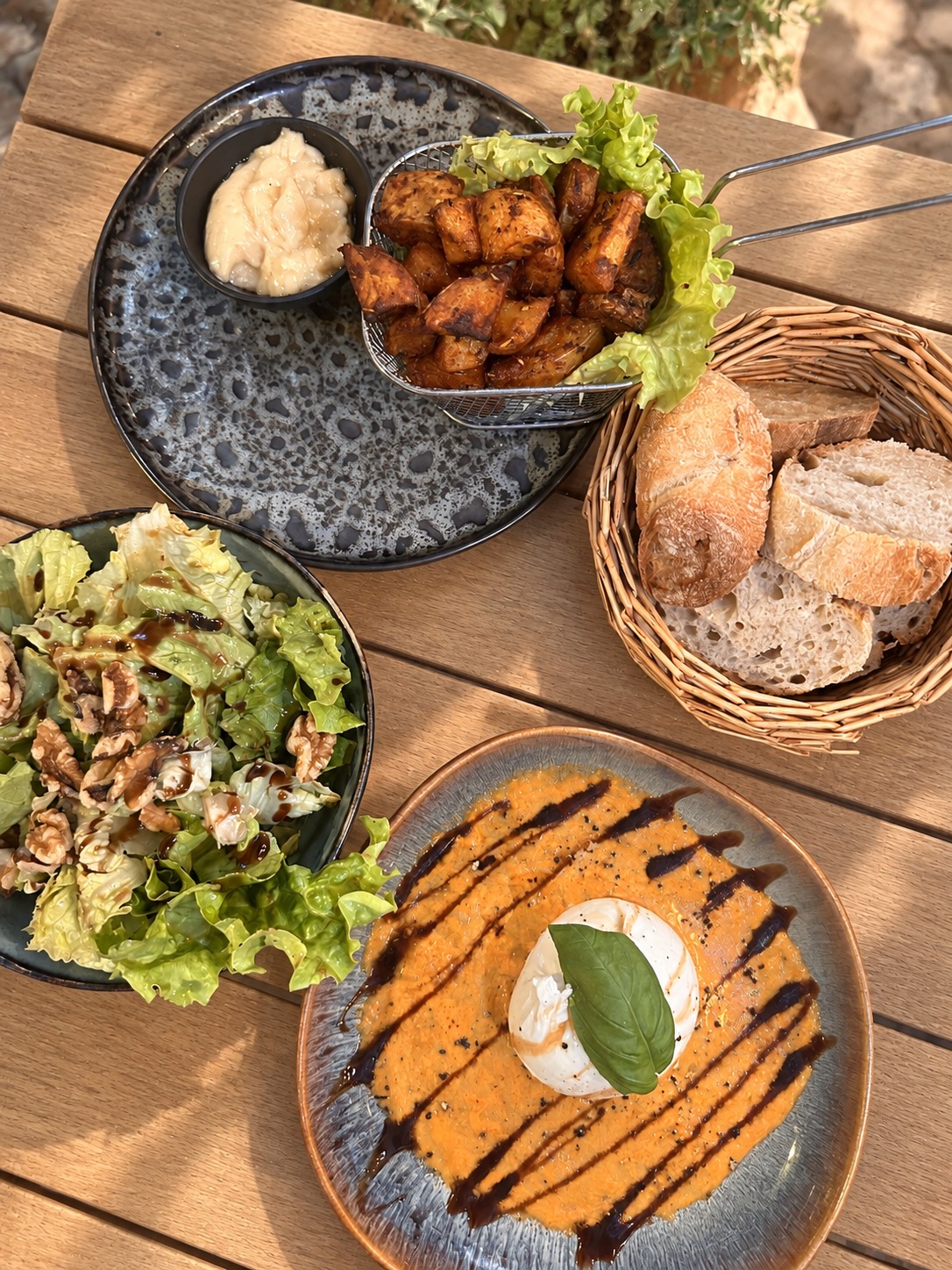 Burrata, pommes de terre, salade et pain sur la table du DiCarlo